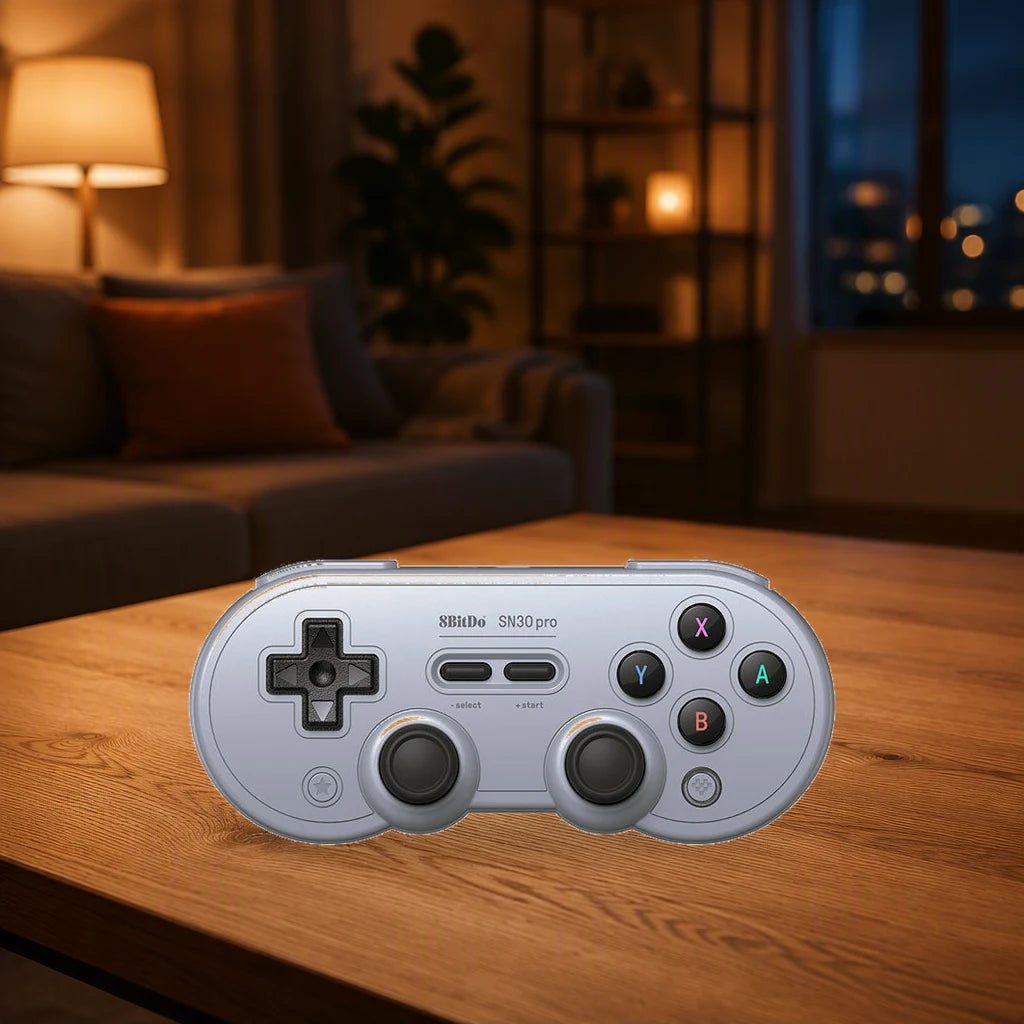 Gray 8BitDo SN30 Pro Hall Effect controller on a coffee table in a warmly lit living room.