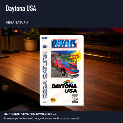 Representative pre-owned Daytona USA (Sega Saturn), product image in a styled desk scene.
