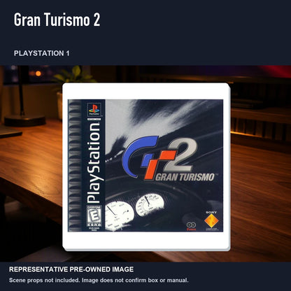 Representative pre-owned Gran Turismo 2 (PlayStation 1), product image in a styled desk scene.
